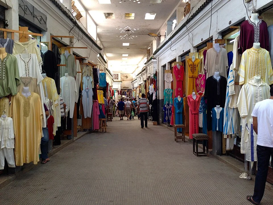 A busy street in the Fes medina where rugs are traded alongside everything else