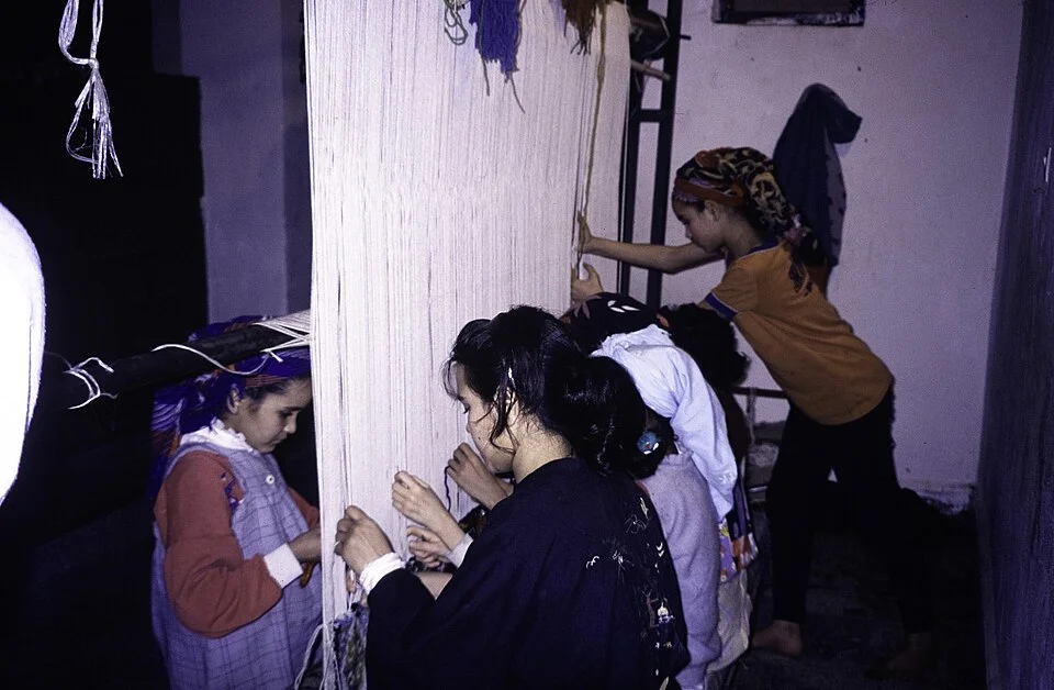 Weavers checking a rug on the loom in Khenifra